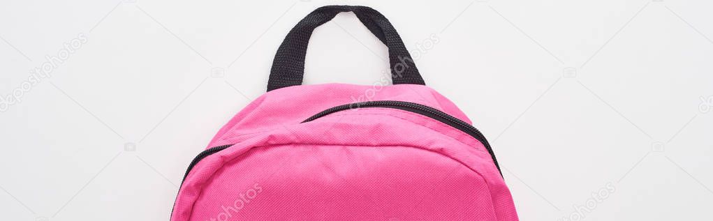 Panoramic shot of closed bright pink school bag isolated on white