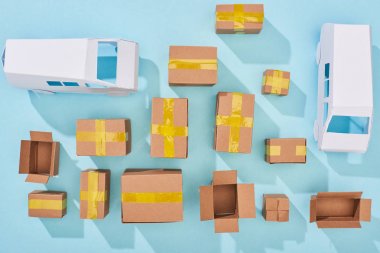 top view of cardboard boxes and white vans on blue background clipart