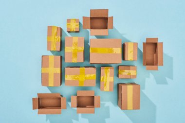 top view of closed and open cardboard boxes on blue background clipart