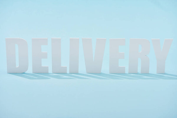 white delivery lettering with shadows on blue background