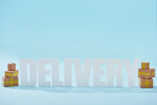 White Delivery Lettering Shadows Closed Cardboard Boxes Blue Background — Stock Photo, Image