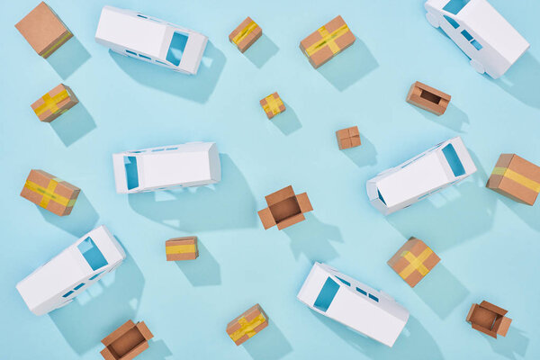 top view of cardboard boxes and mini vans on blue background