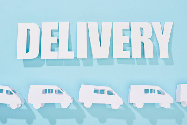 white delivery inscription with shadow above mini vans on blue background
