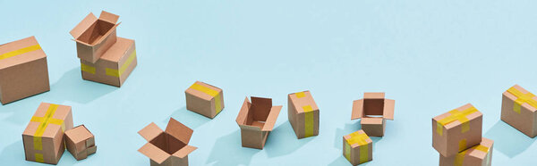 панорамный вид на миниатюрные почтовые ящики с желтой клейкой лентой на синем фоне
