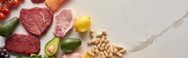 Avokado, limon, mermer yüzeyinde yer fıstığı yakınında ham et biftek panoramik çekim kopya alanı ile