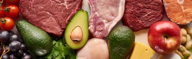 Panoramic shot of raw meat, fish and poultry near avocados, tomatoes, grape, apple cheese and peanuts clipart