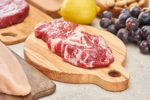 Raw Mmeat Tenderloin Wooden Cutting Board Grapes Lemon Marble Surface — Stock Photo, Image