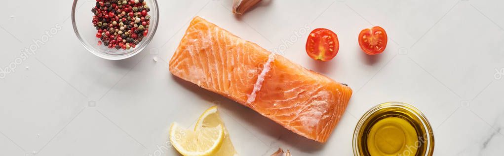 Top view of raw salmon steak near lemon, tomatoes, garlic, oil and peppercorns in bowls on marble table, panoramic shot — Stock Image Top View Raw Salmon Steak Lemon Tomatoes Garlic Oil Peppercorns Stock Photo