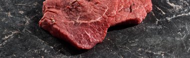 panoramic shot of fresh uncooked beef sirloin on black marble surface clipart