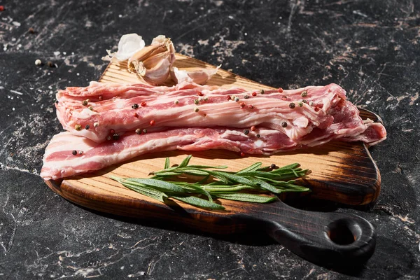 Houten Snijplank Met Rauwe Varkensvlees Plakjes Buurt Van Rozemarijn Knoflook — Stockfoto