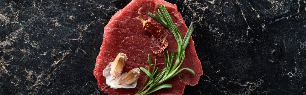 Panoramic shot of raw beef with cayenne pepper, rosemary and garlic on black marble surface — Stock Image Panoramic Shot Raw Beef Cayenne Pepper Rosemary Garlic Black Marble Royalty Free Stock Images