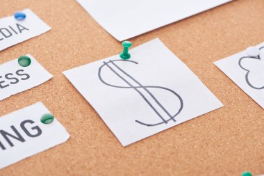 mantar tahtaüzerinde sabitlenmiş dolar işareti ile kağıt kart