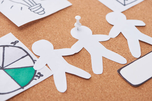 paper artwork pinned on cork office board