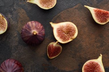 top view of ripe whole and cut tasty figs on stone background clipart