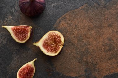 top view of ripe whole and cut delicious figs on stone background clipart
