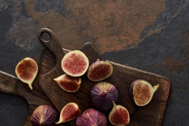 top view of delicious figs and wooden brown cutting boards on stone background clipart