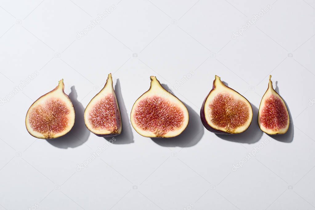 flat lay with ripe cut delicious figs on white background