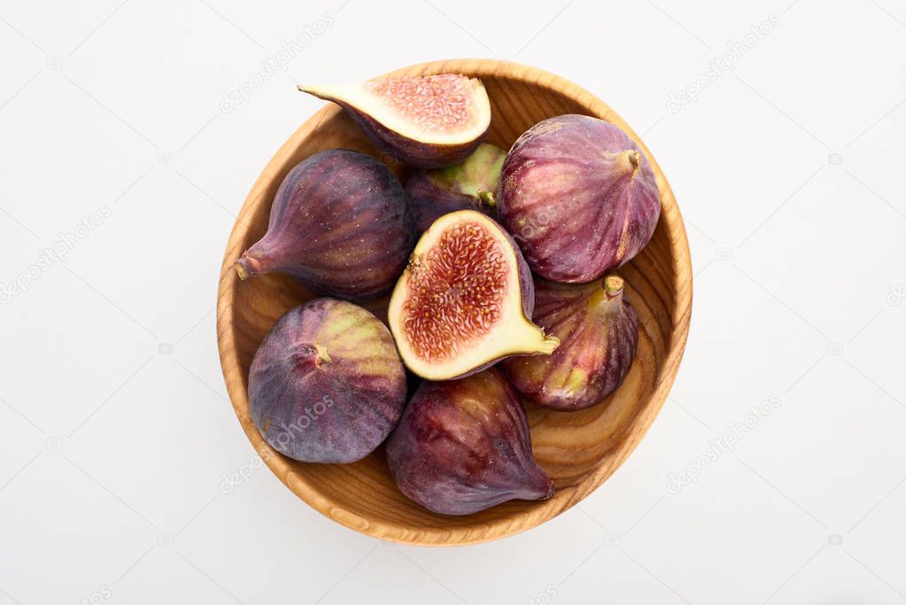 top view of ripe delicious figs in wooden bowl on white background