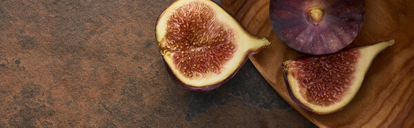 panoramic shot of ripe delicious figs on wooden board on stone background