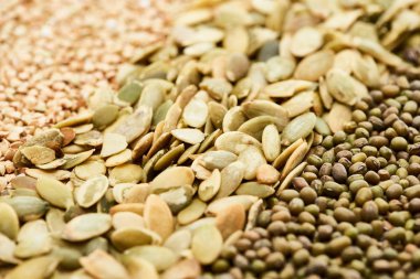 close up view of raw pumpkin seeds near maash and green buckwheat clipart