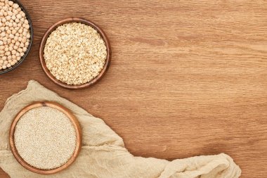 tuval ile ahşap yüzeyüzerinde nohut, yulaf ezmesi ve buğday ile kase üst görünümü