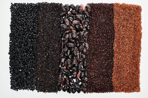 top view of assorted black beans, rice, quinoa and buckwheat isolated on white