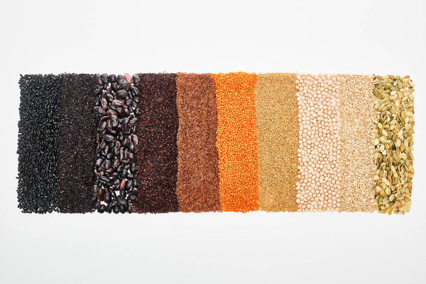 top view of black beans, rice, quinoa, chickpea, pumpkin seeds, buckwheat, and red lentil isolated on white