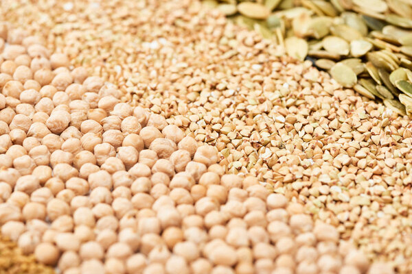 close up view of dry chickpea, raw buckwheat and pumpkin seeds