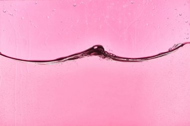 damla ile pembe arka plan üzerinde dalgalı şeffaf tatlı su