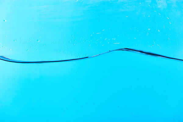 wavy clear water on blue background with drops