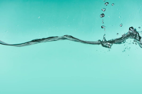 wavy transparent water on turquoise background with splash