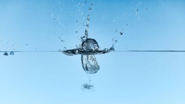 clear water with falling ice cubes and splash on blue background clipart