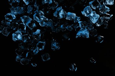 top view of frozen ice cubes with blue light isolated on black clipart