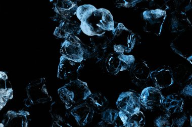 top view of frozen clear ice cubes with blue lighting isolated on black clipart