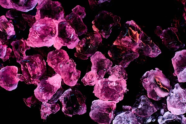黒で分離された紫色のイルミネーションを持つ凍った氷の立方体の上の眺め — ストック写真