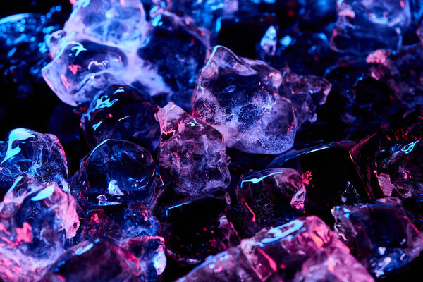 transparent ice cubes with purple light isolated on black