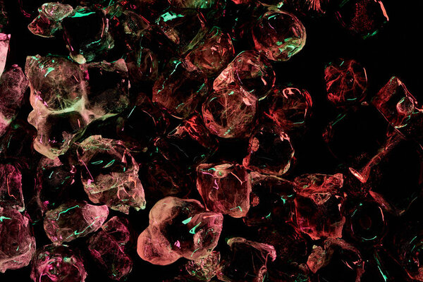 top view of clear ice cubes with red and green light isolated on black