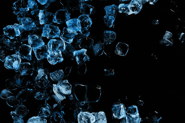 top view of frozen ice cubes with blue light isolated on black