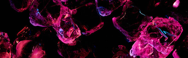 panoramic shot of transparent ice cubes with purple lighting isolated on black