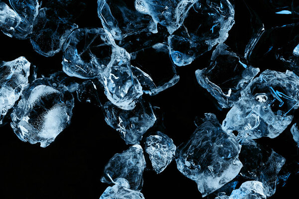 top view of frozen ice cubes with blue lighting isolated on black