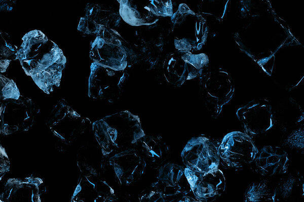 верхний вид замороженных прозрачных кубиков льда с синим освещением изолированы на черный
