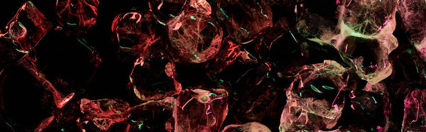 panoramic shot of clear ice cubes with red and green lighting isolated on black