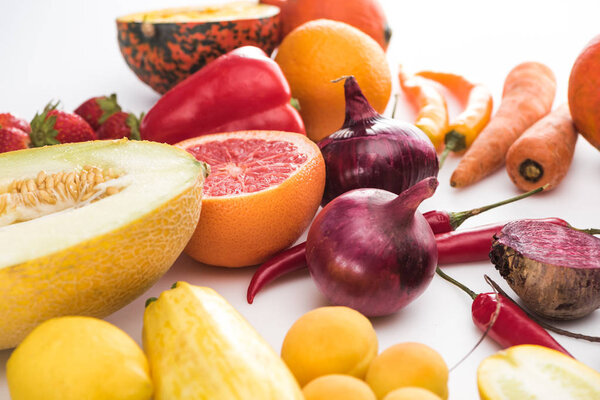 red onions, apricots, carrots, strawberries, peppers and melon on white background