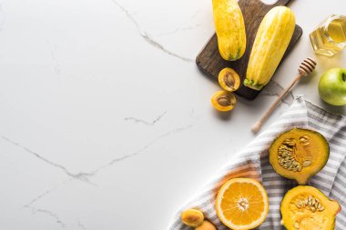 balkabağı, kayısı, kabak ve portakal yanında bal ve mermer yüzeyde ahşap kesme tahtası ile çizgili havlu üst görünümü