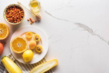 mermer yüzeyinde portakal, kayısı, limon, kabak6 çilek ve bal ile plaka üst görünümü