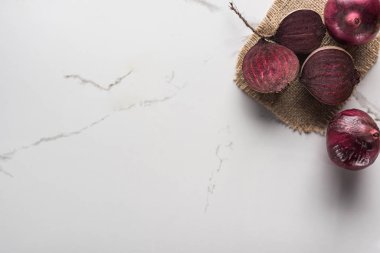 hessian ile mermer yüzeyinde kırmızı soğan ve pancar yarım üst görünümü