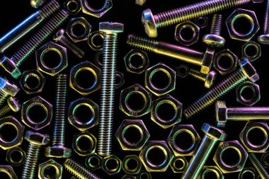 top view of scattered metallic bolts and nuts isolated on black clipart