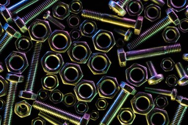 top view of scattered steel bolts and nuts isolated on black clipart