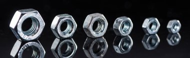 panoramic shot of shiny metallic nuts row isolated on black clipart
