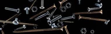 panoramic shot of scattered screws isolated on black clipart